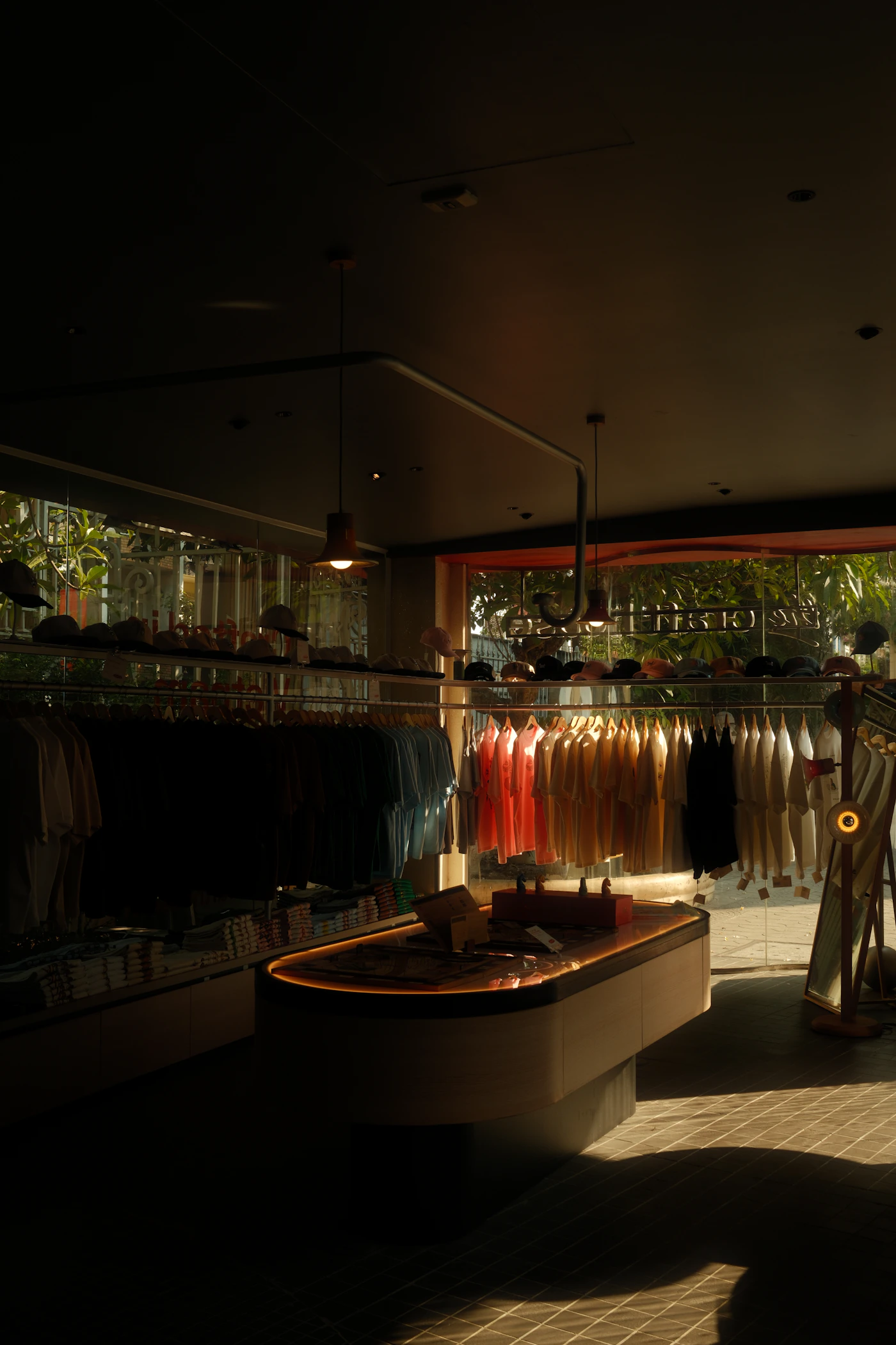 Clothing rails and folded stock in a softly lit contemporary shop